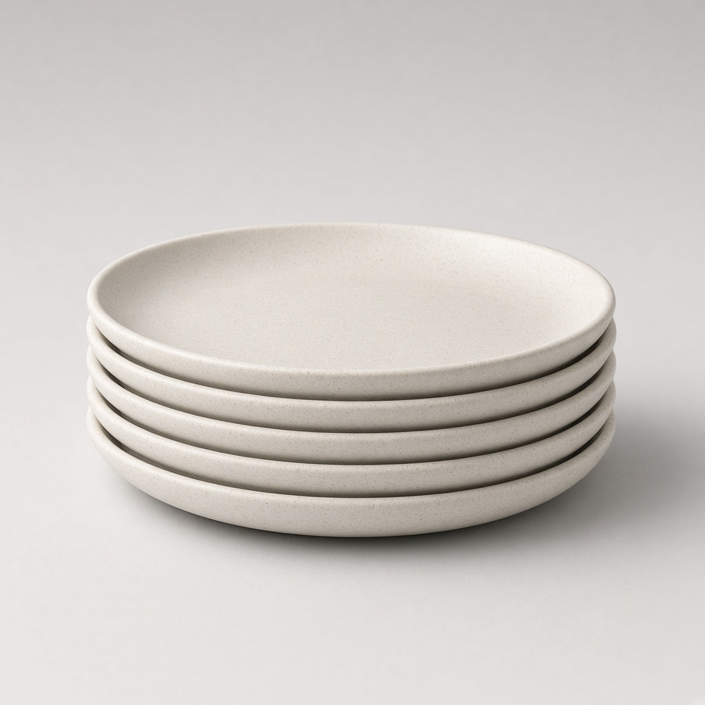 Stack of four Feld Kitchen oatmeal stoneware dinner plates